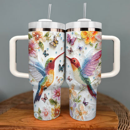 Glänzender, glänzender Becher mit Blumen-Kolibri und Schmetterlingen