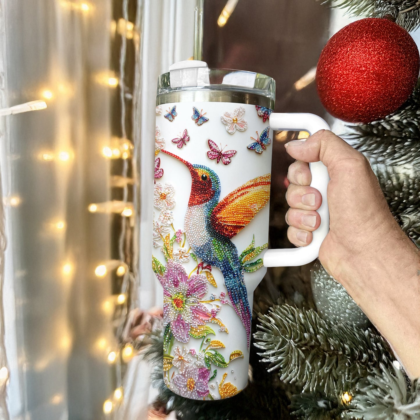 Glänzender, glänzender Becher mit Blütenkolibri und Schmetterlingen