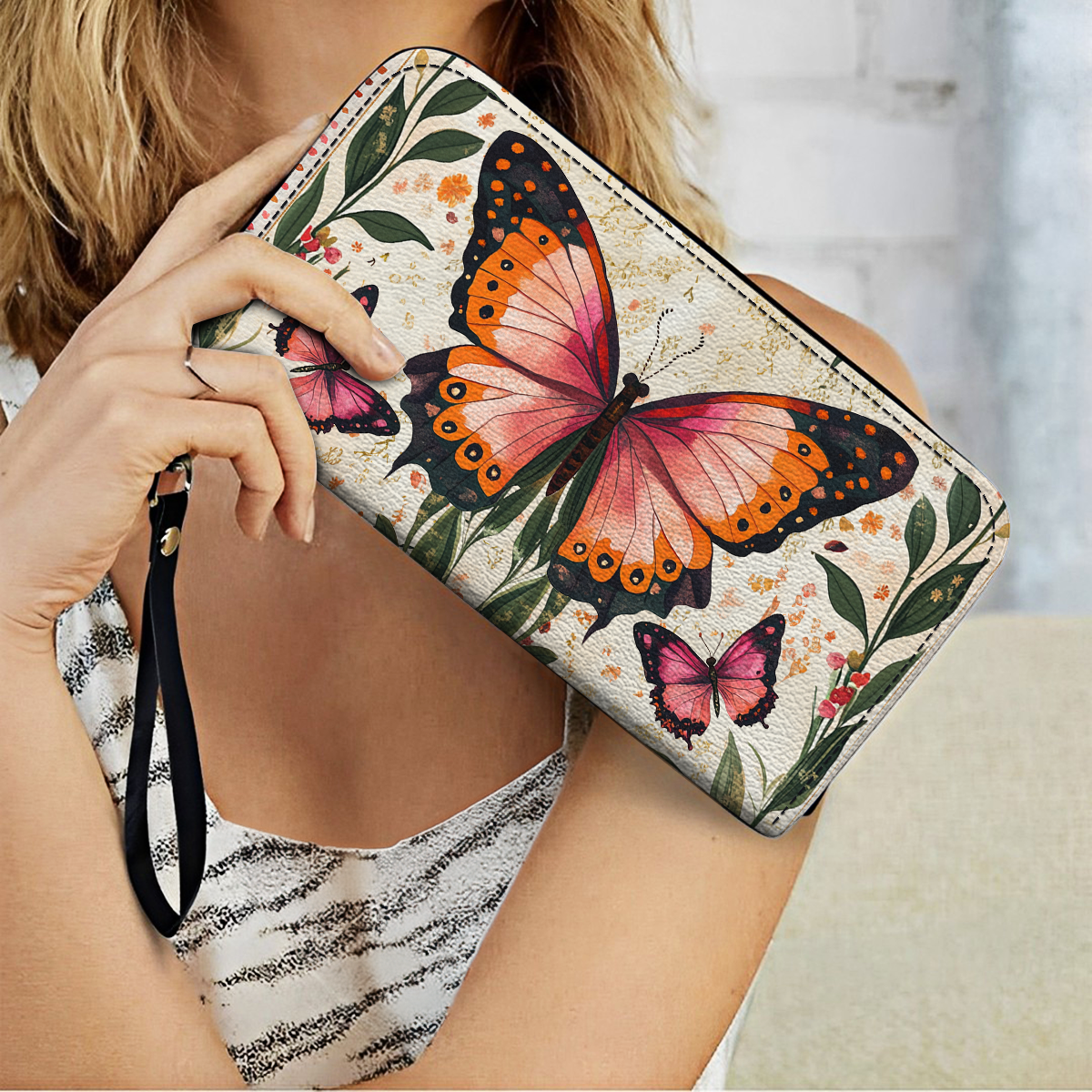 Pochette en cuir brillant avec dragonne et poignée Winged Elegance