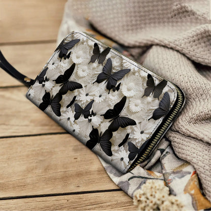 Pochette en cuir brillant avec dragonne et papillon noir