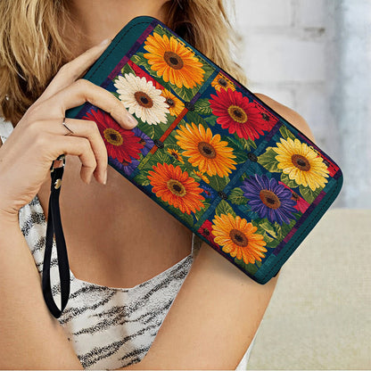 Glänzende Clutch aus Leder mit Trageriemen und leuchtendem Gänseblümchen-Aufnäher