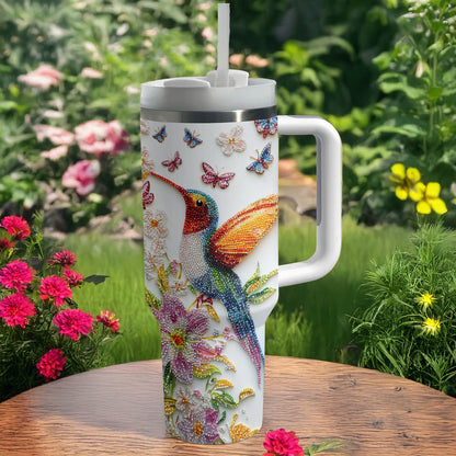 Glänzender, glänzender Becher mit Blütenkolibri und Schmetterlingen