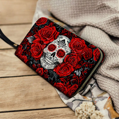 Pochette en cuir brillant avec dragonne et poignée élégante en forme de tête de mort et de roses rouges