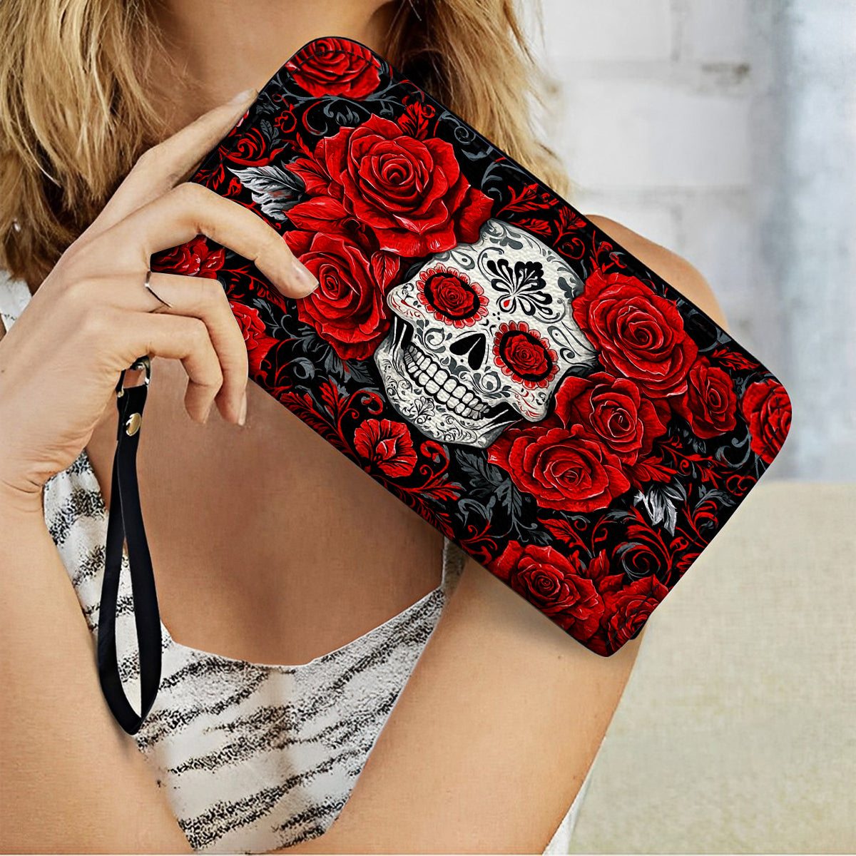 Pochette en cuir brillant avec dragonne et poignée élégante en forme de tête de mort et de roses rouges