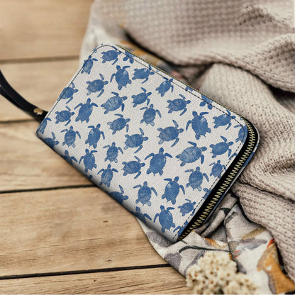 Pochette en cuir brillant avec dragonne et poignée en forme de tortue de mer douce